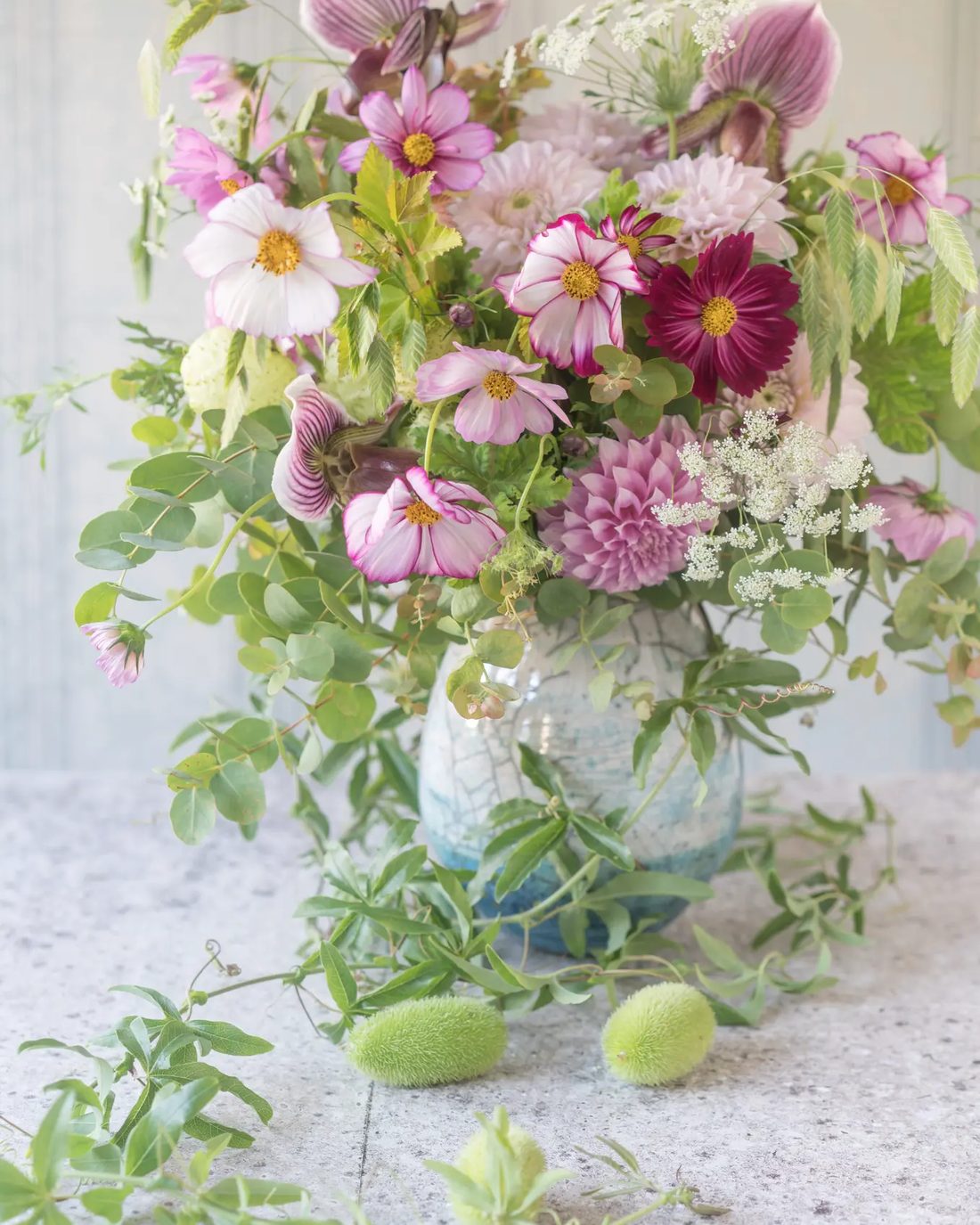 ガラスの器に生けた淡い色の花