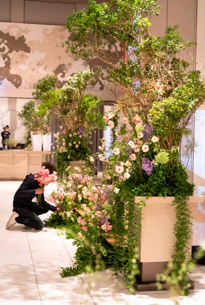 会場に大きな装花を設えるフローリスト